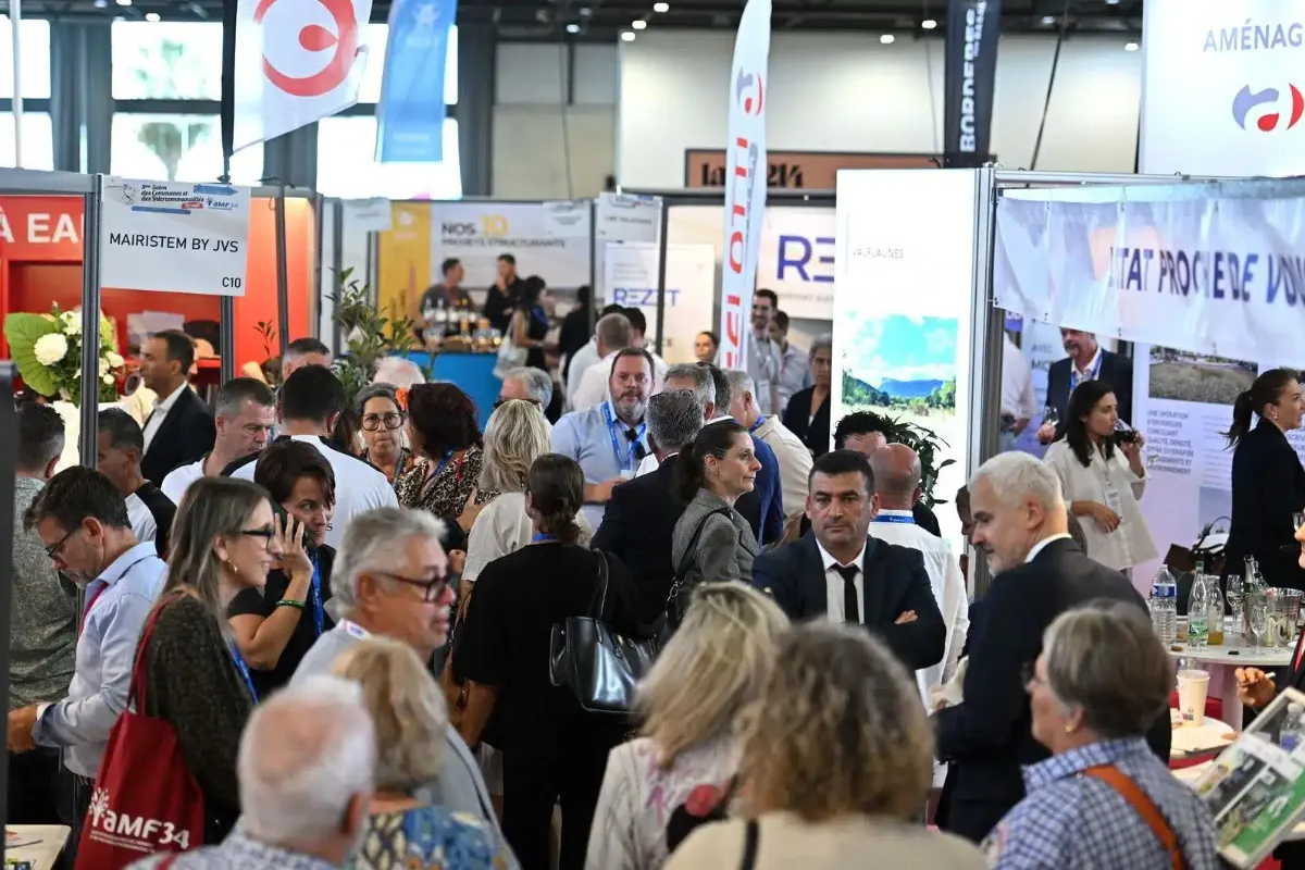 Visiteurs et exposants dans les allées d’un salon des Maires, des Communes et des Intercommunalités